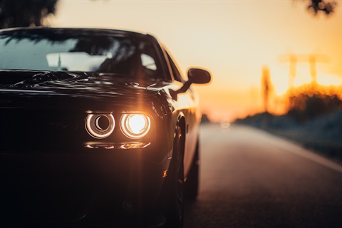 luxurious-car-parked-highway-with-illuminated-headlight-sunset_compressed.jpg